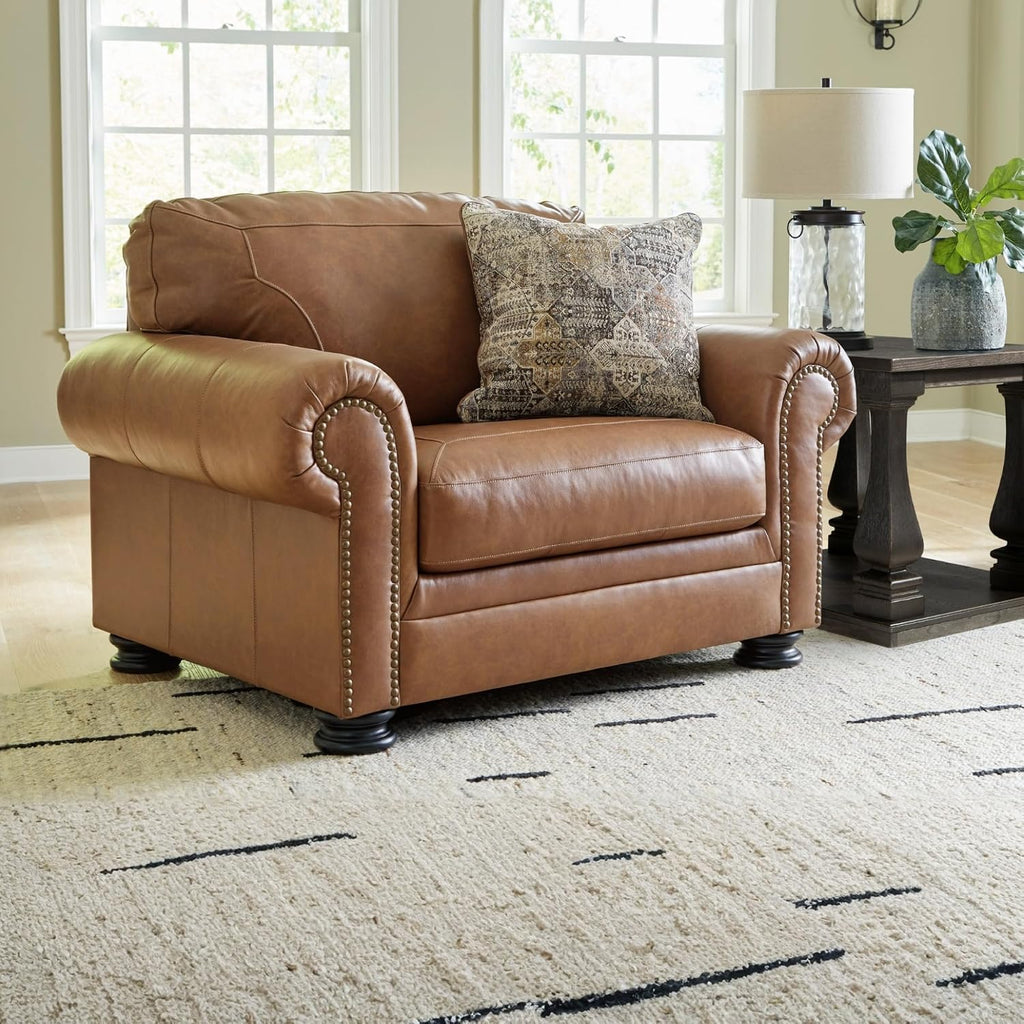 Signature Design by Ashley Carianna Oversized Leather Accent Chair, Caramel | Top-grain leather seating, Durable faux leather outer panels, Extra-wide 54 in frame, Traditional living room style