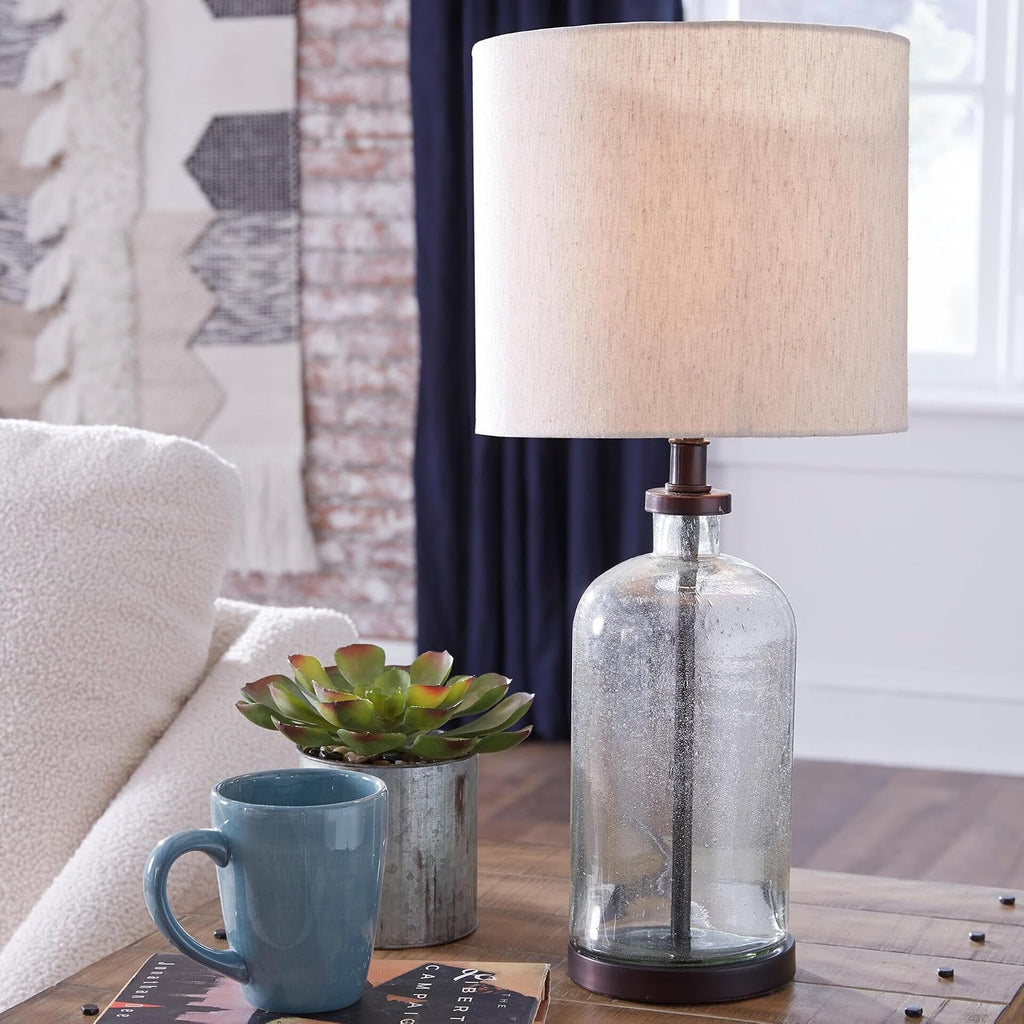Signature Design by Ashley Bandile Seeded Glass Bedside Table Lamp, Bronze | Textured clear glass base, Light fabric drum shade, Modern farmhouse style, Living room reading spaces