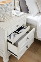 Signature Design by Ashley Tall Antique White Nightstand Wood Bedside Table | Two dovetail drawers, Hidden pull-out tray for valuables, Textured antiqued white oak finish, Robbinsdale Series