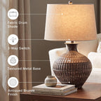 Signature Design by Ashley Magan Metal Table Lamp, 28", Antique Bronze | Antique bronze-tone metal base, Textured pattern, Fabric modified drum shade, Living room or entryway use, 3-way switch