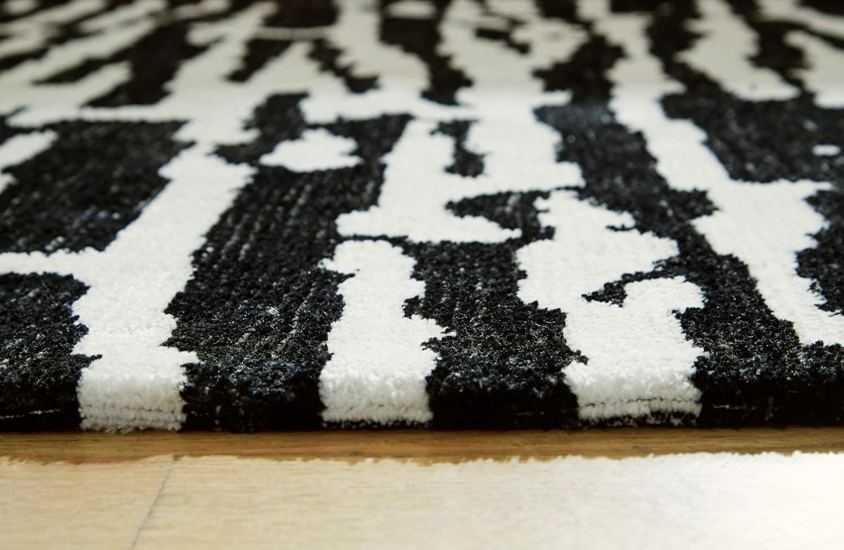 Signature Design by Ashley Bramshaw Area Rug, 8x10, Black and Ivory | Plush 9 mm medium-pile polyester, Protective woven cotton backing, Contemporary high-contrast pattern