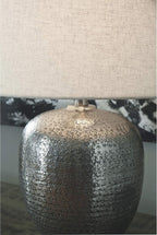 Signature Design by Ashley Magalie Metal Table Lamp, Antiqued Silver | Textured hammered aluminum base, Vintage warmth, Crisp modified drum shade, Cozy living room lighting